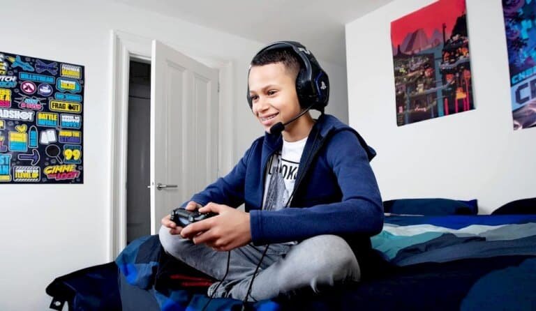Un enfant équipé d'un casque gamer pour PS 5 joue à un jeu vidéo