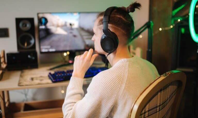Un homme équipé d'un casque gaming joue à un jeu vidéo