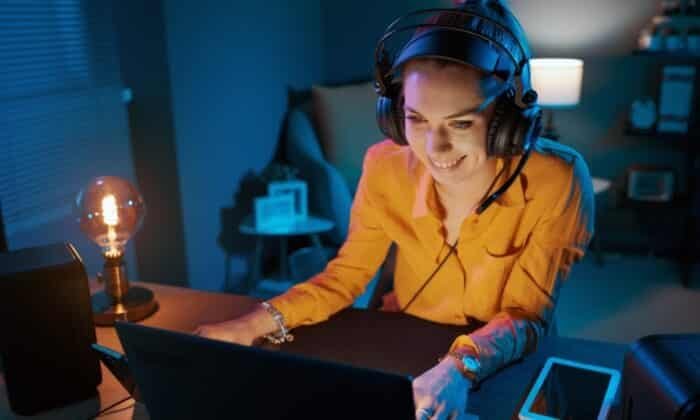 Une femme équipée d'un casque gaming pas cher joue à un jeu vidéo