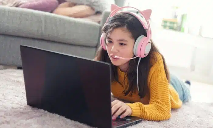 Une femme &eacute;quip&eacute;e d'un casque gamer pour PS4 et PS5 joue &agrave; un jeu vid&eacute;o