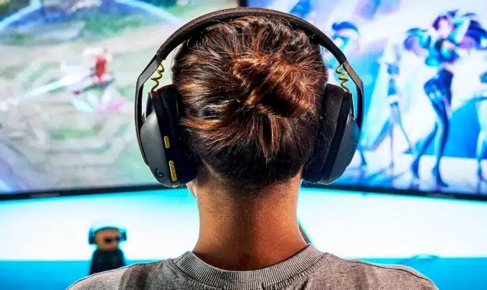 Une personne &eacute;quip&eacute;e d'un casque gamer pour PS4 et PS5 joue &agrave; un jeu vid&eacute;o