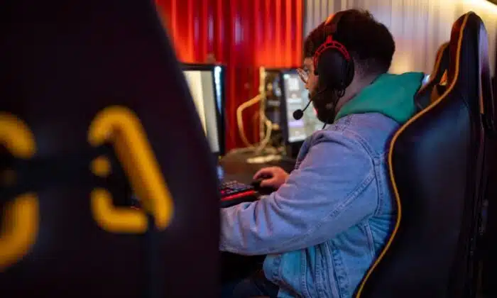 Un homme &eacute;quip&eacute; d'un casque gamer pour PS4 et PS5 joue &agrave; un jeu vid&eacute;o