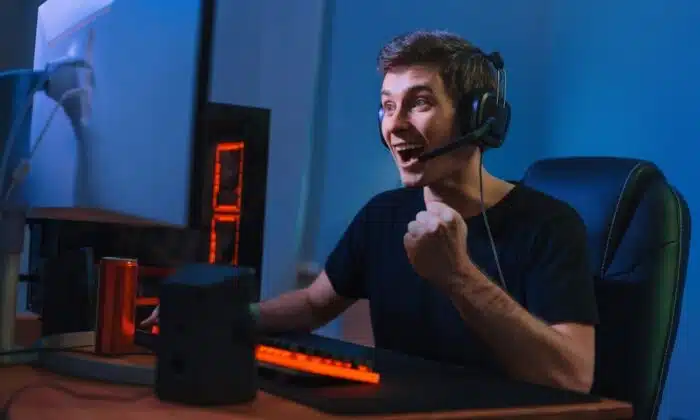 Un homme &eacute;quip&eacute; d'un casque gamer pour PS4 et PS5 joue &agrave; un jeu vid&eacute;o